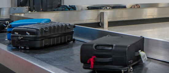 Koffers op bagageband vliegveld - BagageKiezer.nl